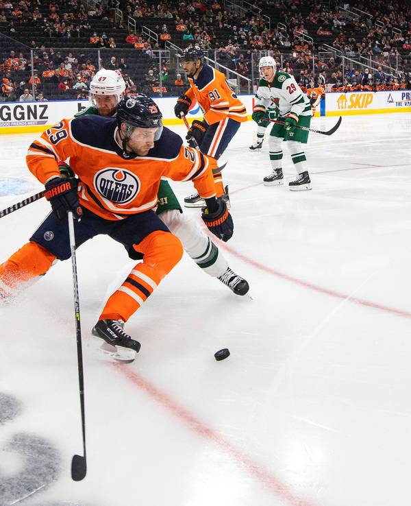 Alex Goligoski attackiert Leon Draisaitl (vorne) auf dem Eis beim Kampf um den Puck.
