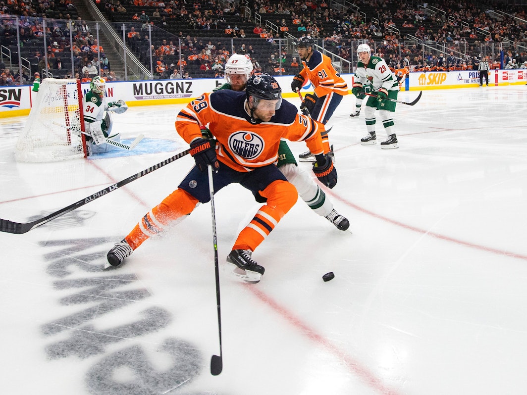 Alex Goligoski attackiert Leon Draisaitl (vorne) auf dem Eis beim Kampf um den Puck.