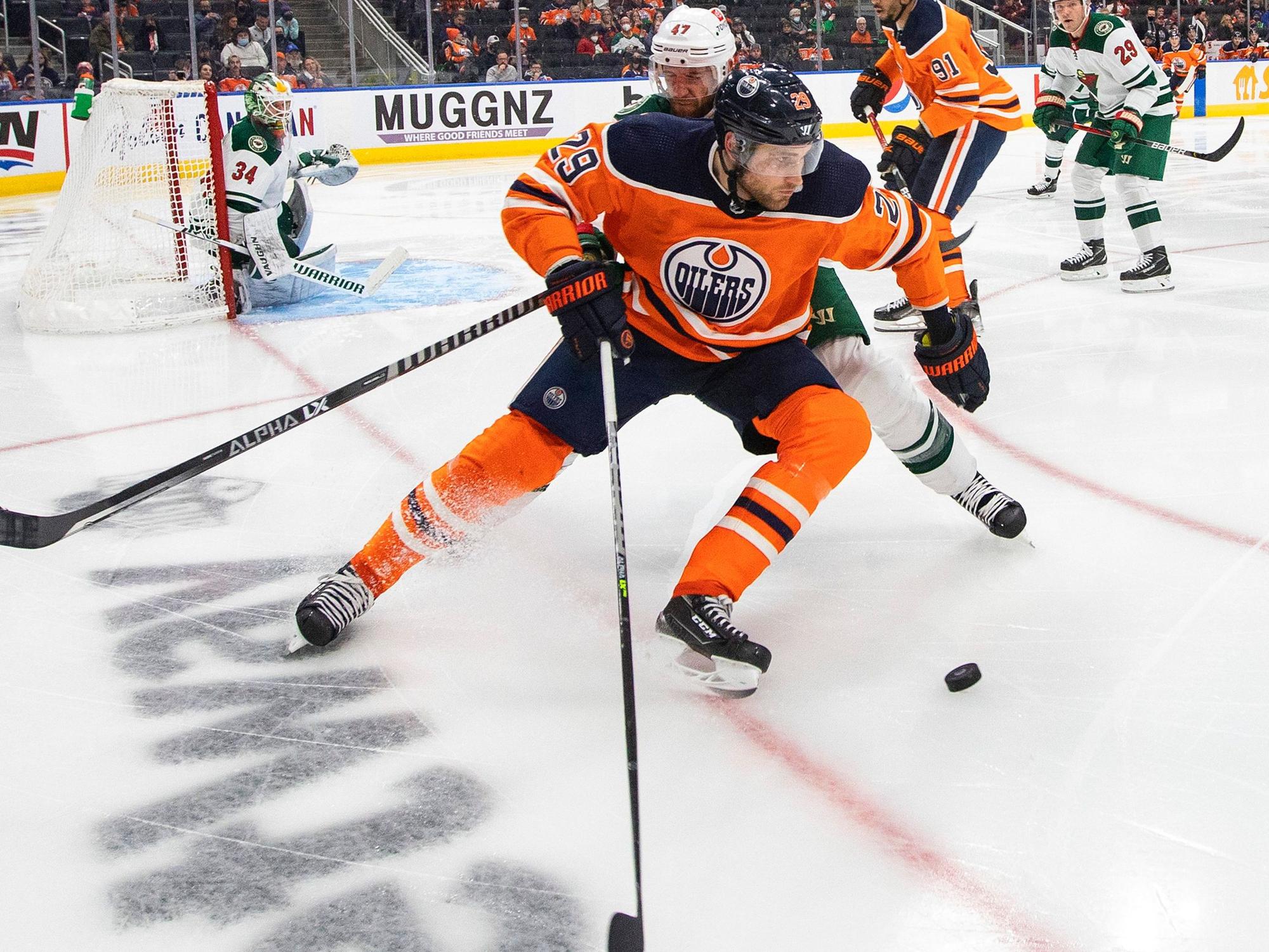 Alex Goligoski attackiert Leon Draisaitl (vorne) auf dem Eis beim Kampf um den Puck.