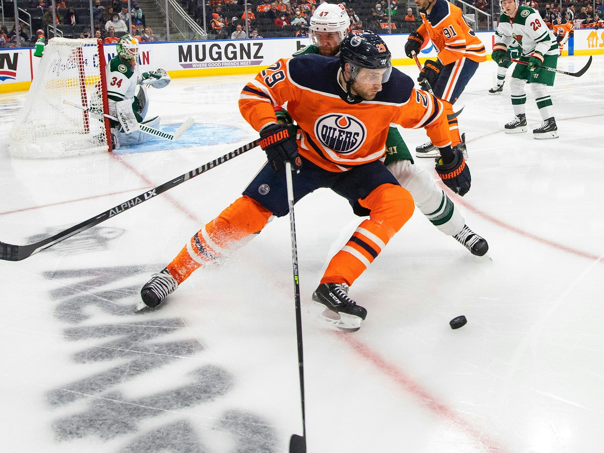 Alex Goligoski attackiert Leon Draisaitl (vorne) auf dem Eis beim Kampf um den Puck.