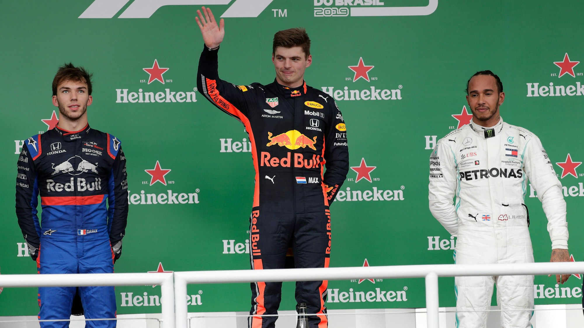 Sieger Max Verstappen (M) aus den Niederlanden vom Team Red Bull Racing, steht auf dem Podium mit dem zweitplatzierten Pierre Gasly (l) aus Frankreich vom Team Toro Rosso und dem drittplatzierten Lewis Hamilton aus Großbritannien vom Team Mercedes.