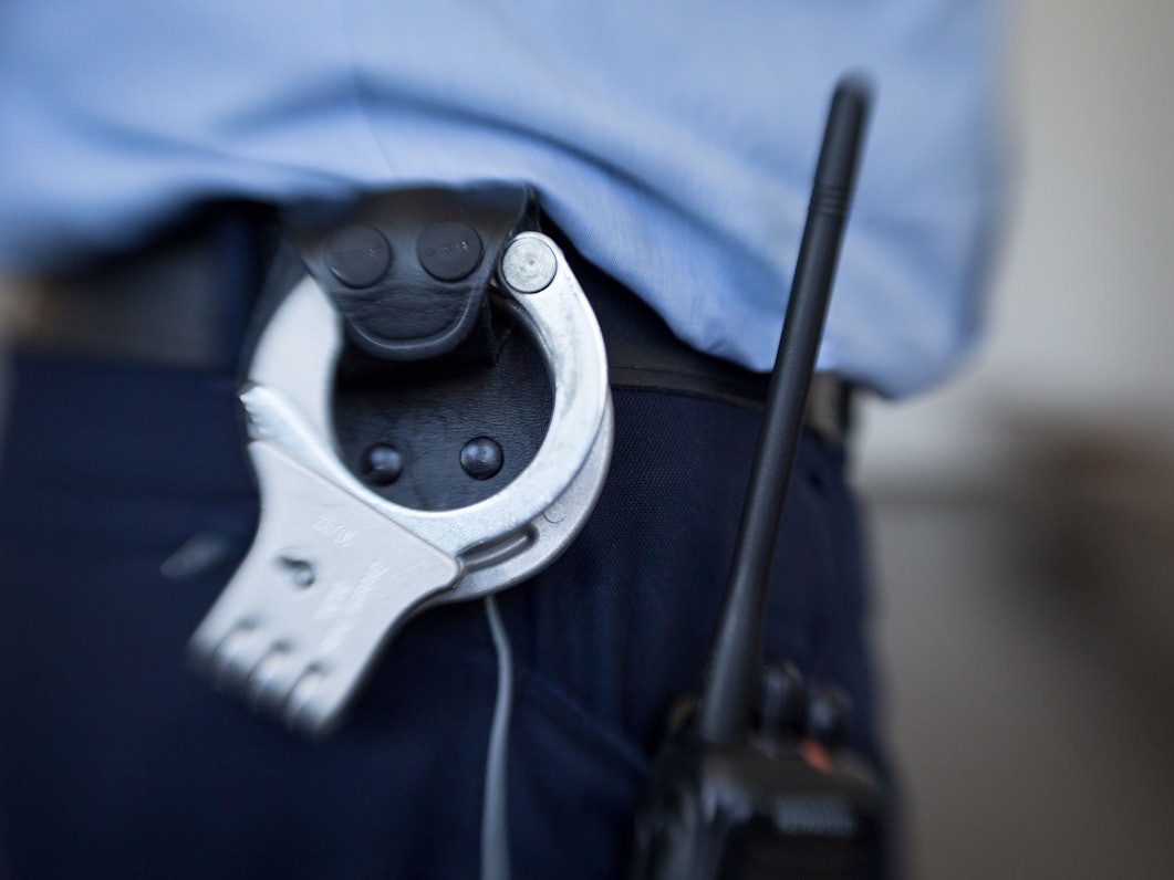 Blick auf die Handschellen eines Polizisten