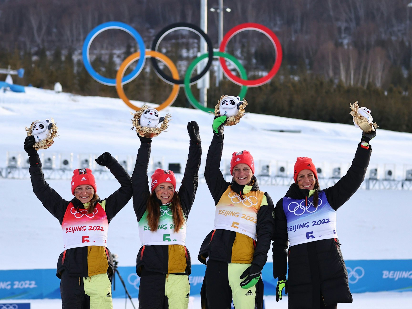 Deutschlands Zweitplatzierte Katherine Sauerbrey, Katharina Hennig, Victoria Carl und Sofie Krehl (l-r) auf dem Podium nach dem Staffel-Rennen der Langlauf-Damen am 12. Februar 2022.