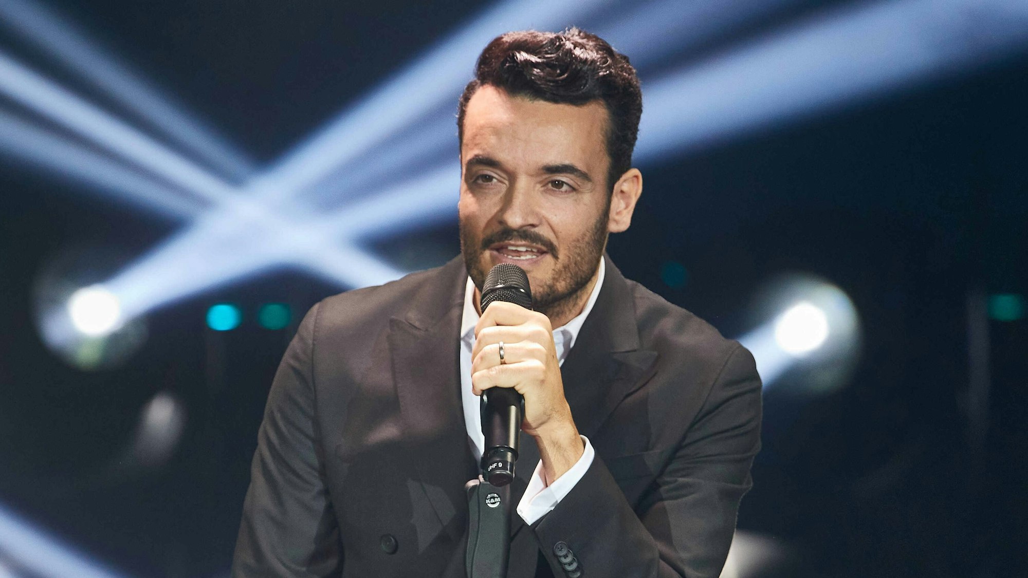 Giovanni Zarrella hält das Mikrofon in der Hand.