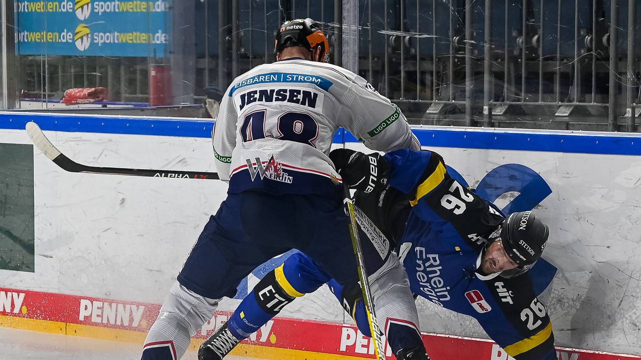 Nicholas B. Jensen drückt Kölns David McIntyre in die Bande.