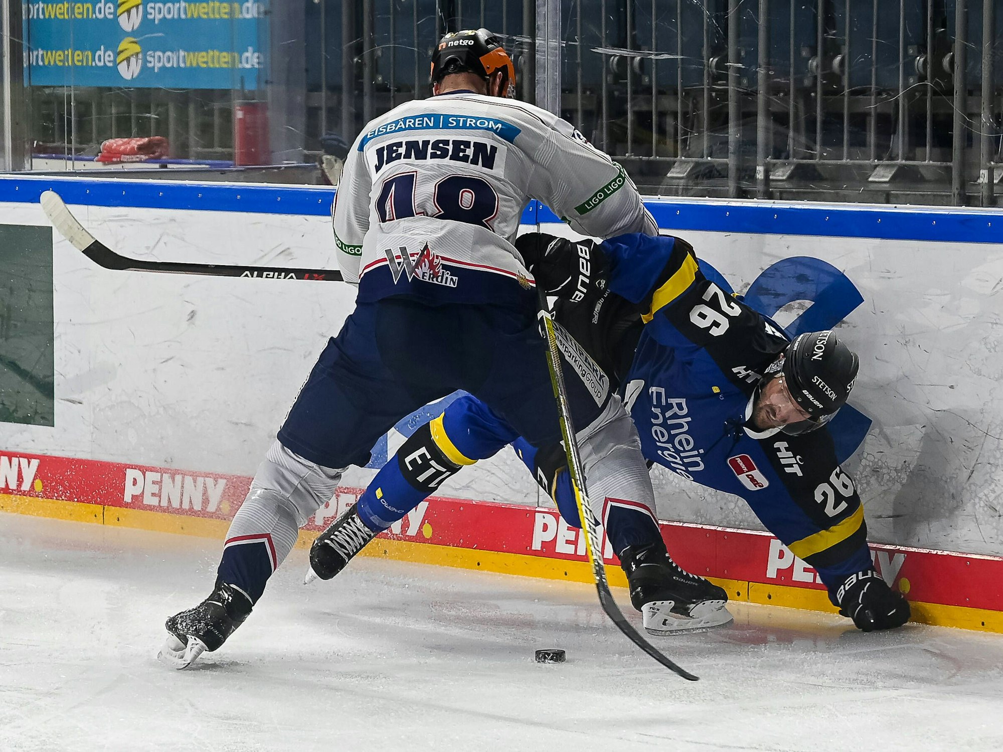 Nicholas B. Jensen drückt Kölns David McIntyre in die Bande.