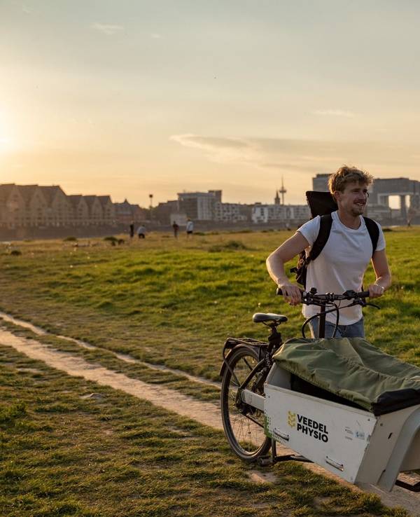 Jonas Eiken auf seinem Lastenfahrrad vor dem Dom-Panorama.