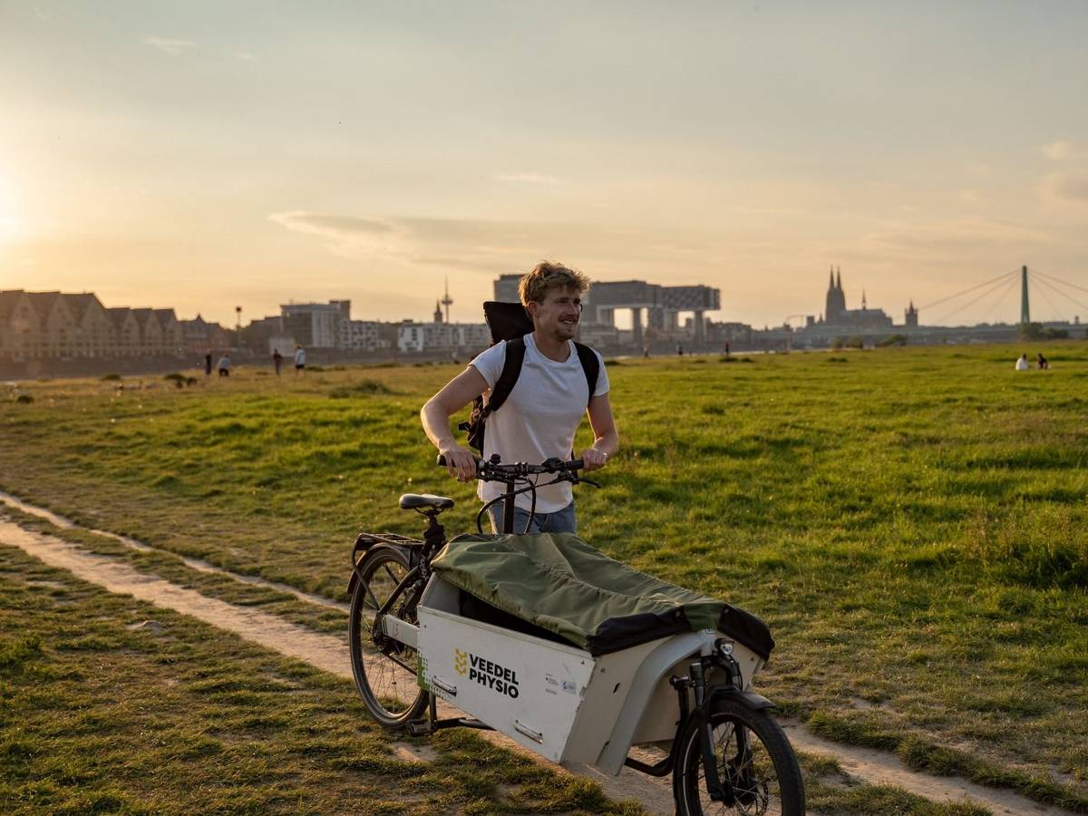 Jonas Eiken auf seinem Lastenfahrrad vor dem Dom-Panorama.