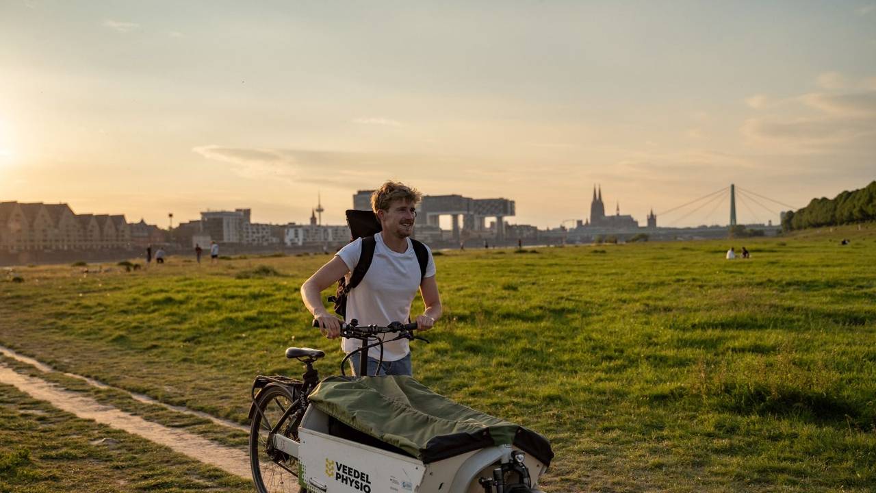 Jonas Eiken auf seinem Lastenfahrrad vor dem Dom-Panorama.