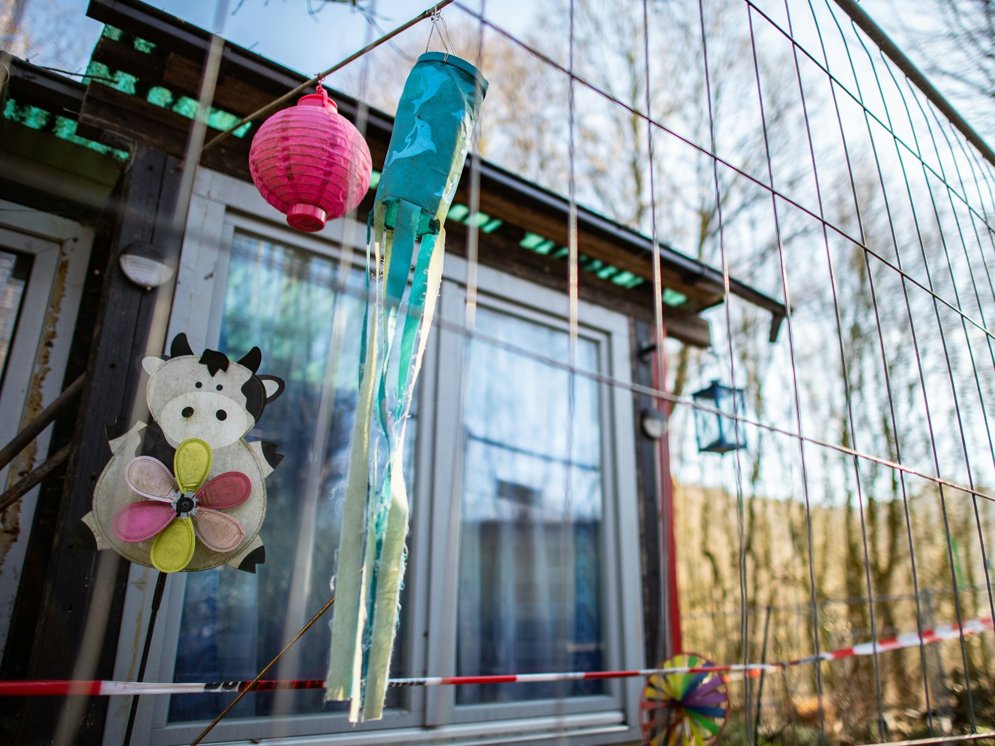 Windspiele hängen an der mittlerweile eingezäunten Campinghütte eines mutmaßlichen Sexualstraftäters auf dem Campingplatz Eichwald.