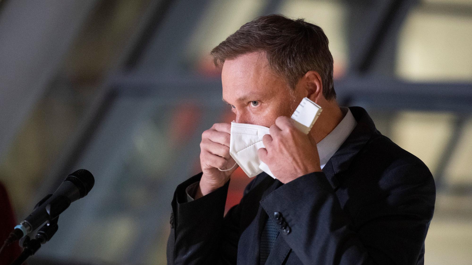 23.02.2022, Berlin: Christian Lindner (FDP), Bundesfinanzminister, setzt nach einer Pressekonferenz nach dem Koalitionsausschuss seine Mund-Nasen-Schutz-Maske wieder auf. Foto: Christophe Gateau/dpa +++ dpa-Bildfunk +++