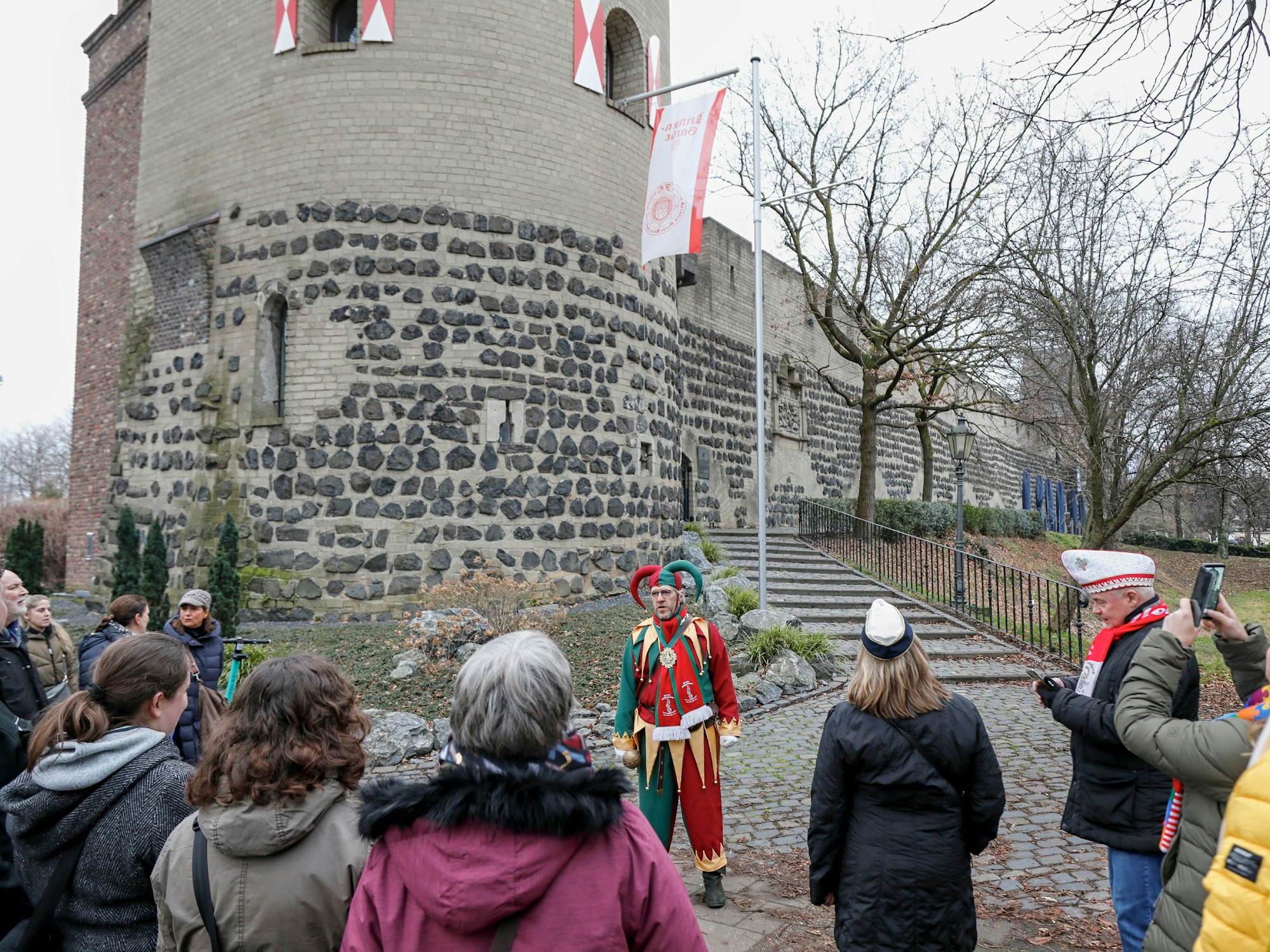 Bellejeck Alfred Wolf steht bei der Bellejeck op Tour-Stadtführung mit den Teilnehmenden vor dem Sachsenturm am Kartäuserwall.