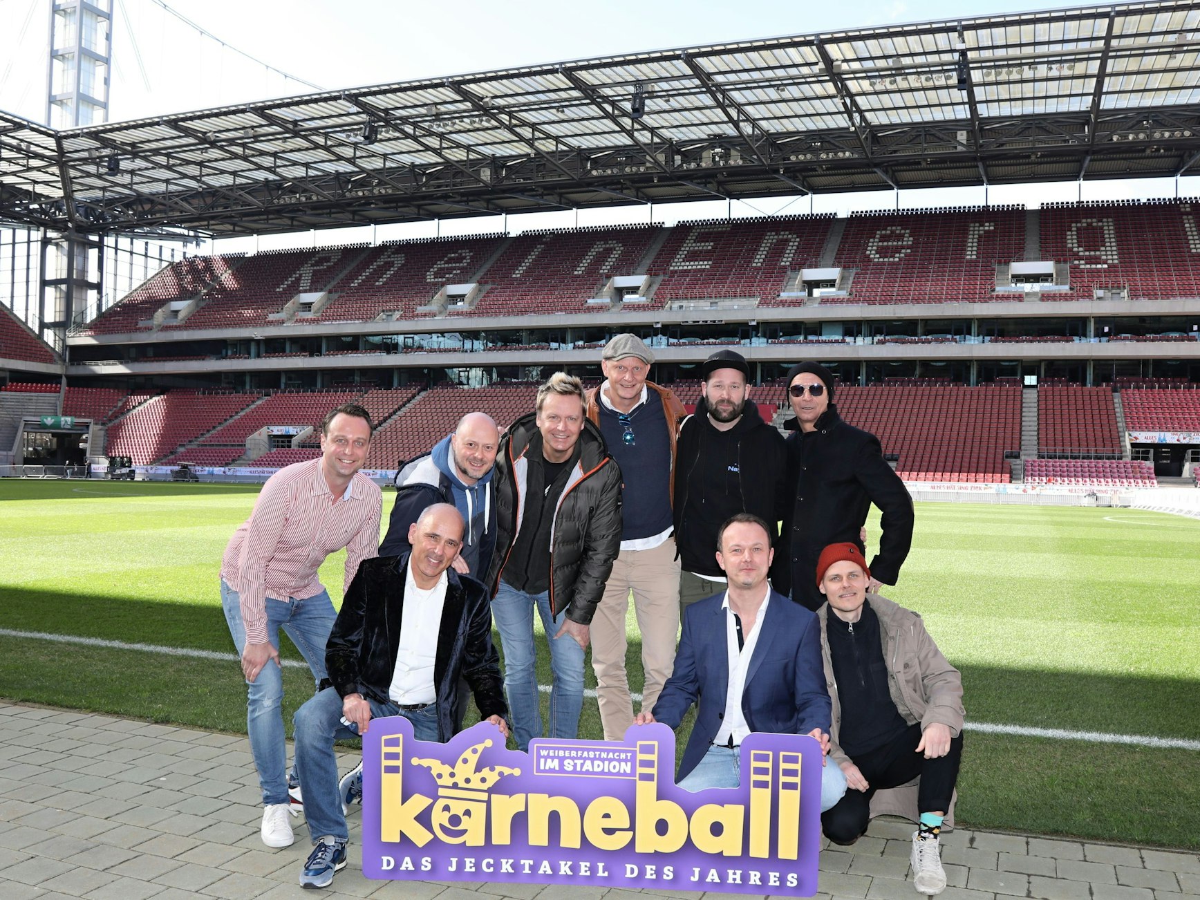 Künstler posieren im Stadion in Köln und schauen in die Kamera.