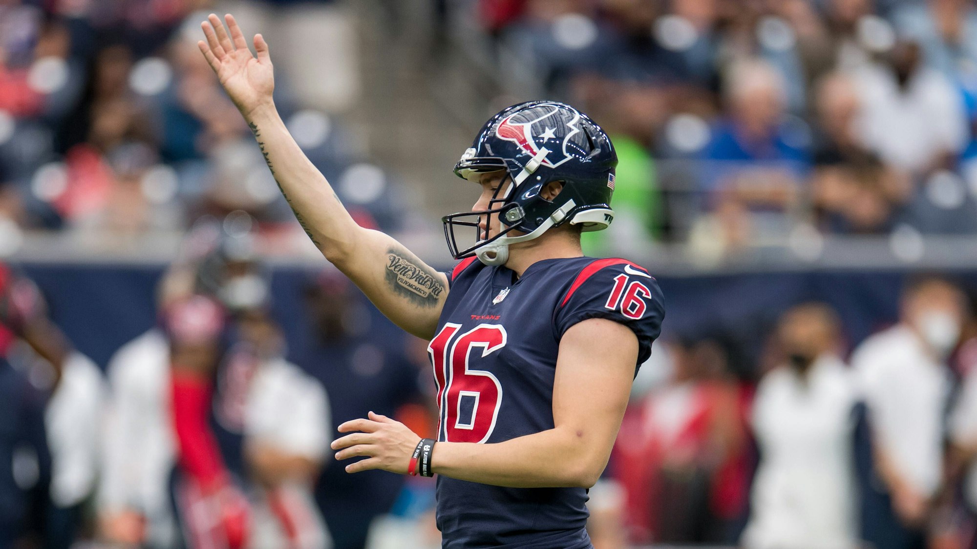 Dominik Eberle hebt im Trikot der Houston Texans den Arm.