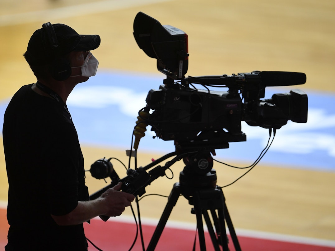 Ein Kameramann bei der Übertragung eines Basketball-Spiels.