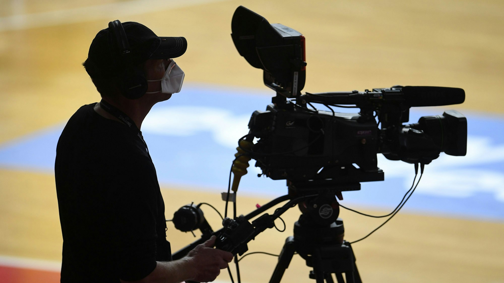 Ein Kameramann bei der Übertragung eines Basketball-Spiels.