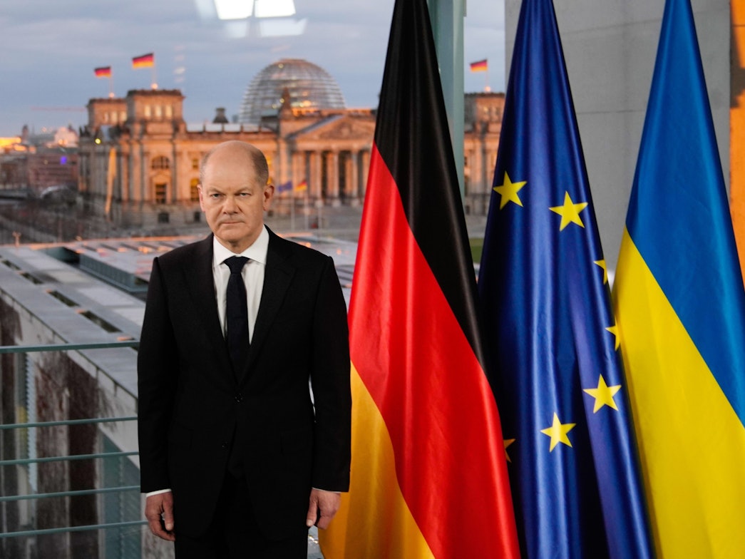 Bundeskanzler Olaf Scholz steht bei einer Fernsehansprache zur Lage zwischen Russland und der Ukraine vor den Fahnen von Deutschland, der EU und der Ukraine.