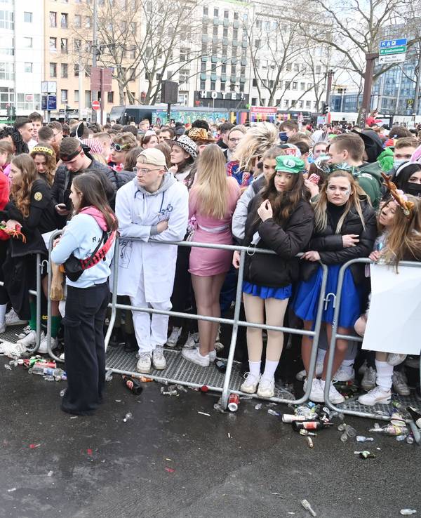 Menschen stehen am Absperrgitter an der Zülpicher Straße.
