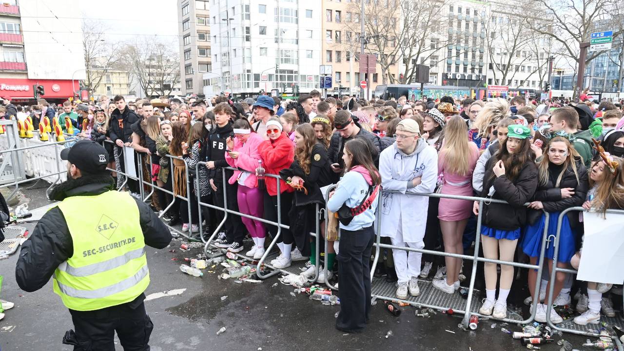 Menschen stehen am Absperrgitter an der Zülpicher Straße.
