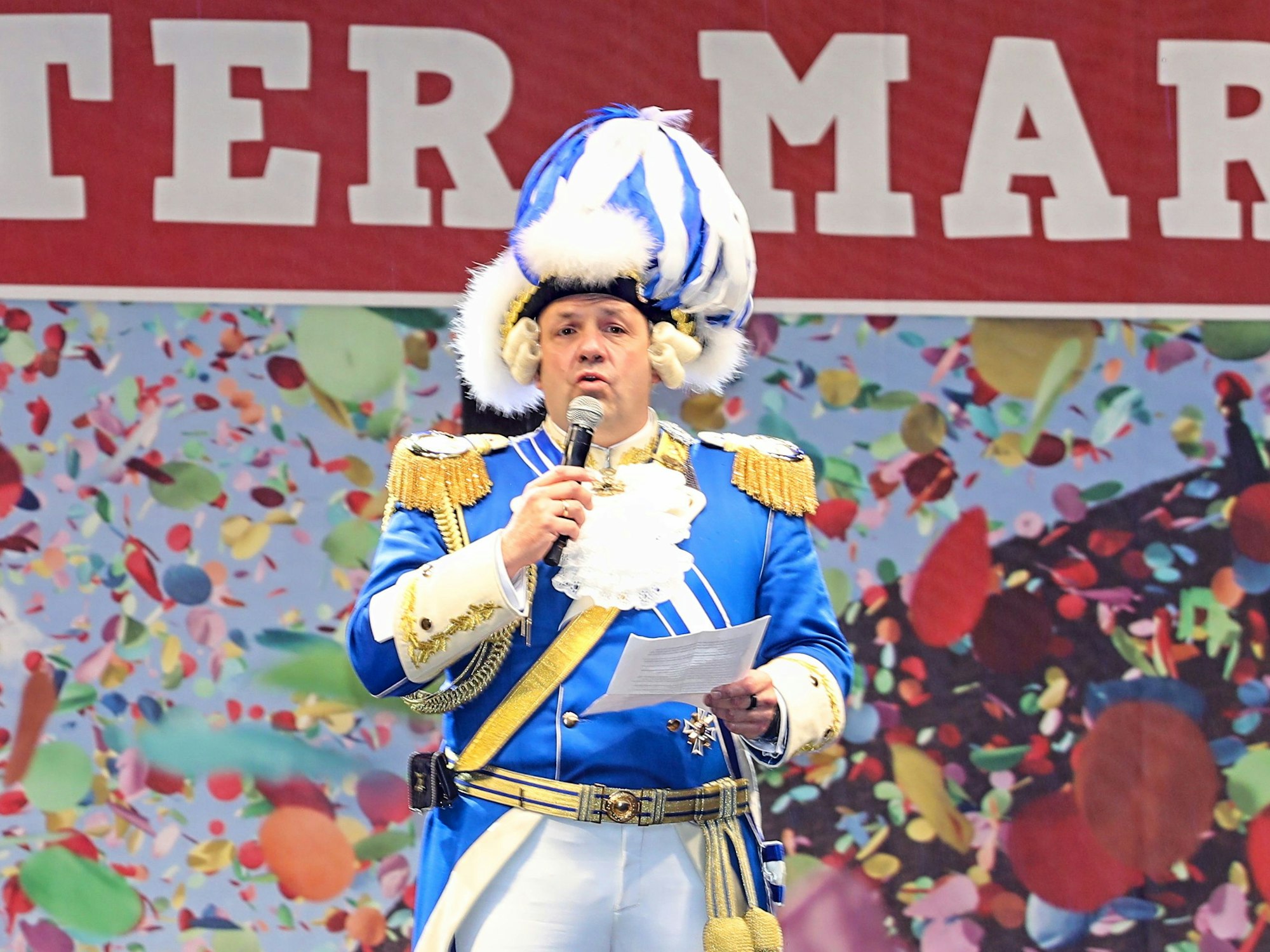 Präsident Björn Griesemann mit Mikrofon auf einer Bühne.