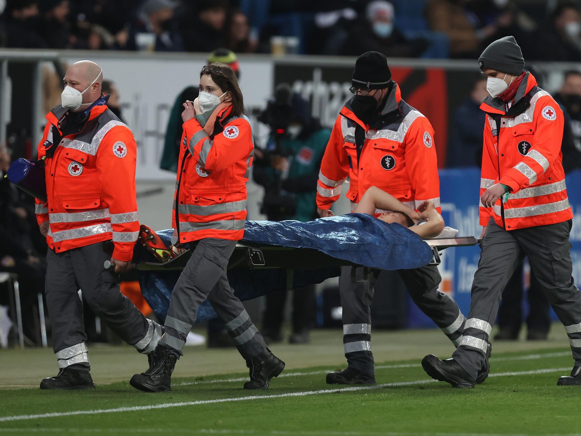 Hoffenheims Geiger muss von vier Sanitätern mit einer Trage vom Platz transportiert werden.