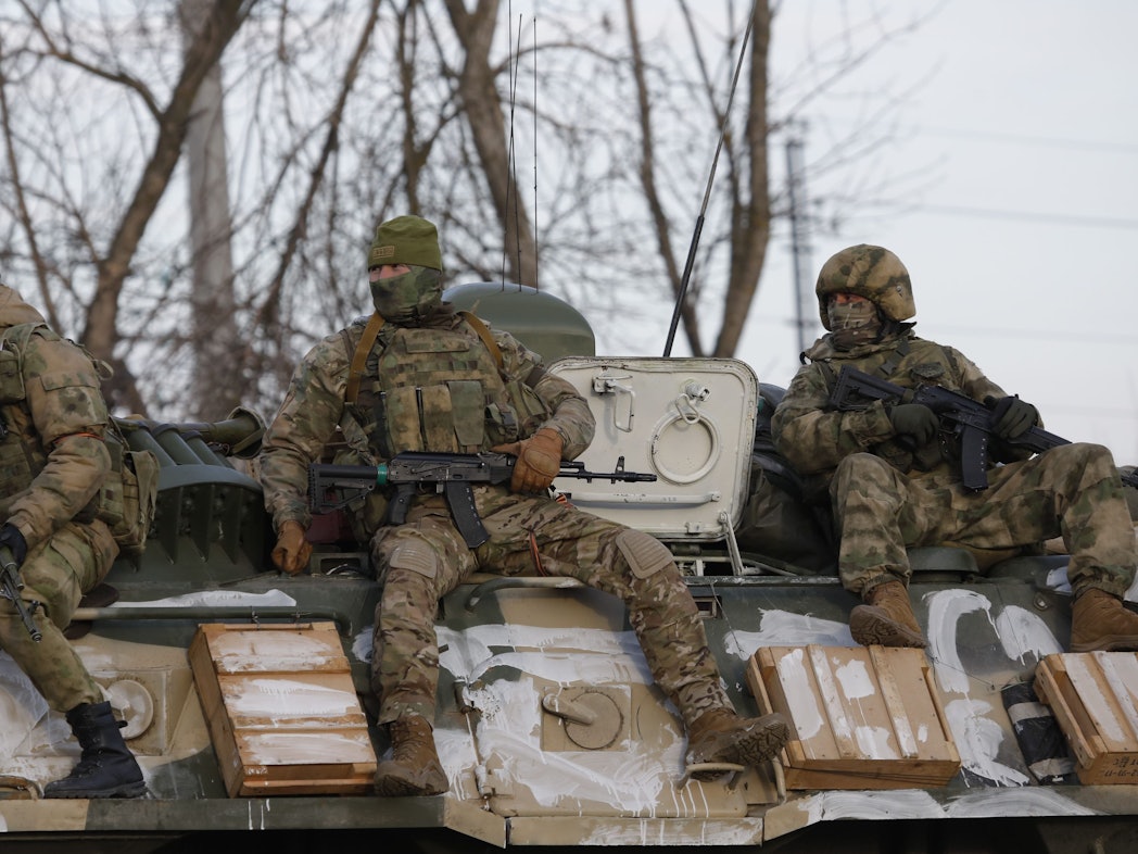 Das von der staatlichen russischen Nachrichtenagentur Sputnik veröffentlichte Bild zeigt russische Soldaten die auf einem gepanzerten Fahrzeug auf einer Straße nahe der Grenze zwischen Russland und der Ukraine mitfahren.