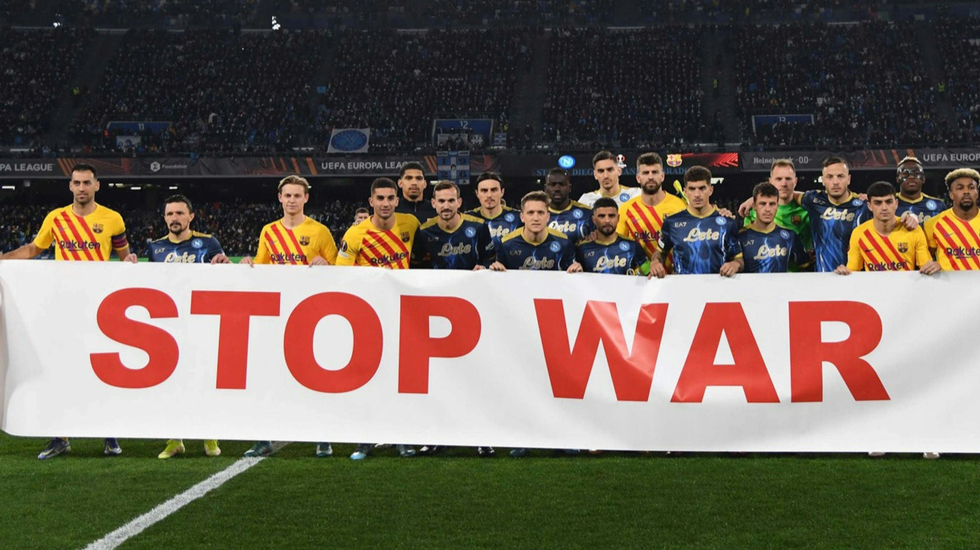 Spieler des FC Barcelona und des SSC Neapel mit einem Banner gegen den Ukraine-Krieg.