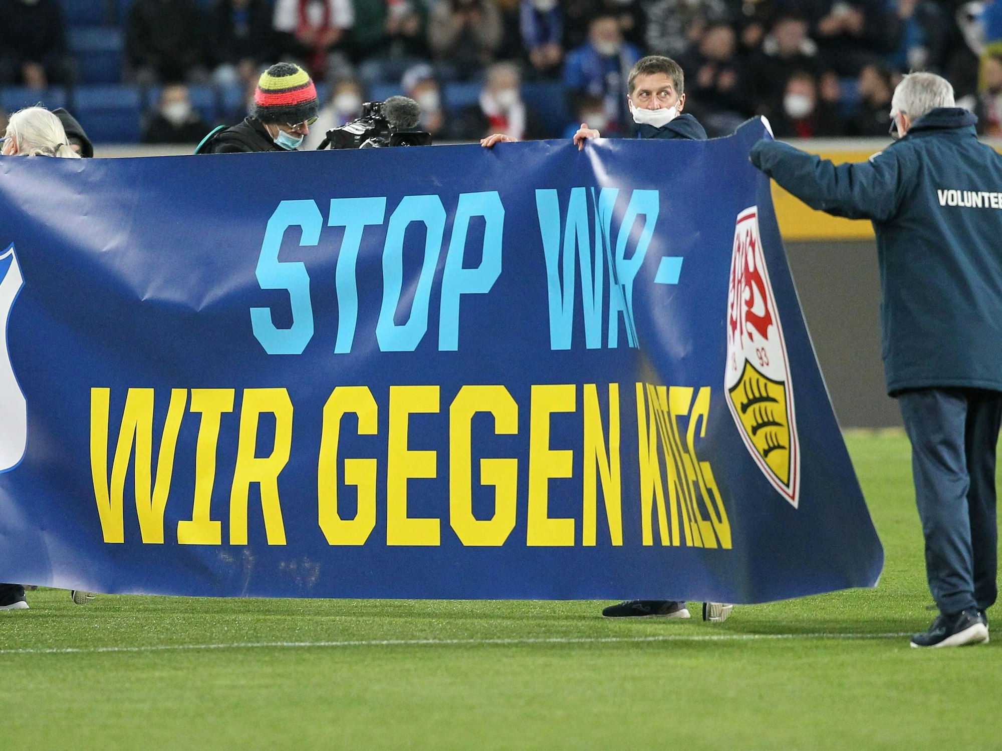 Fußball-Funktionäre halten ein Plakat hoch.