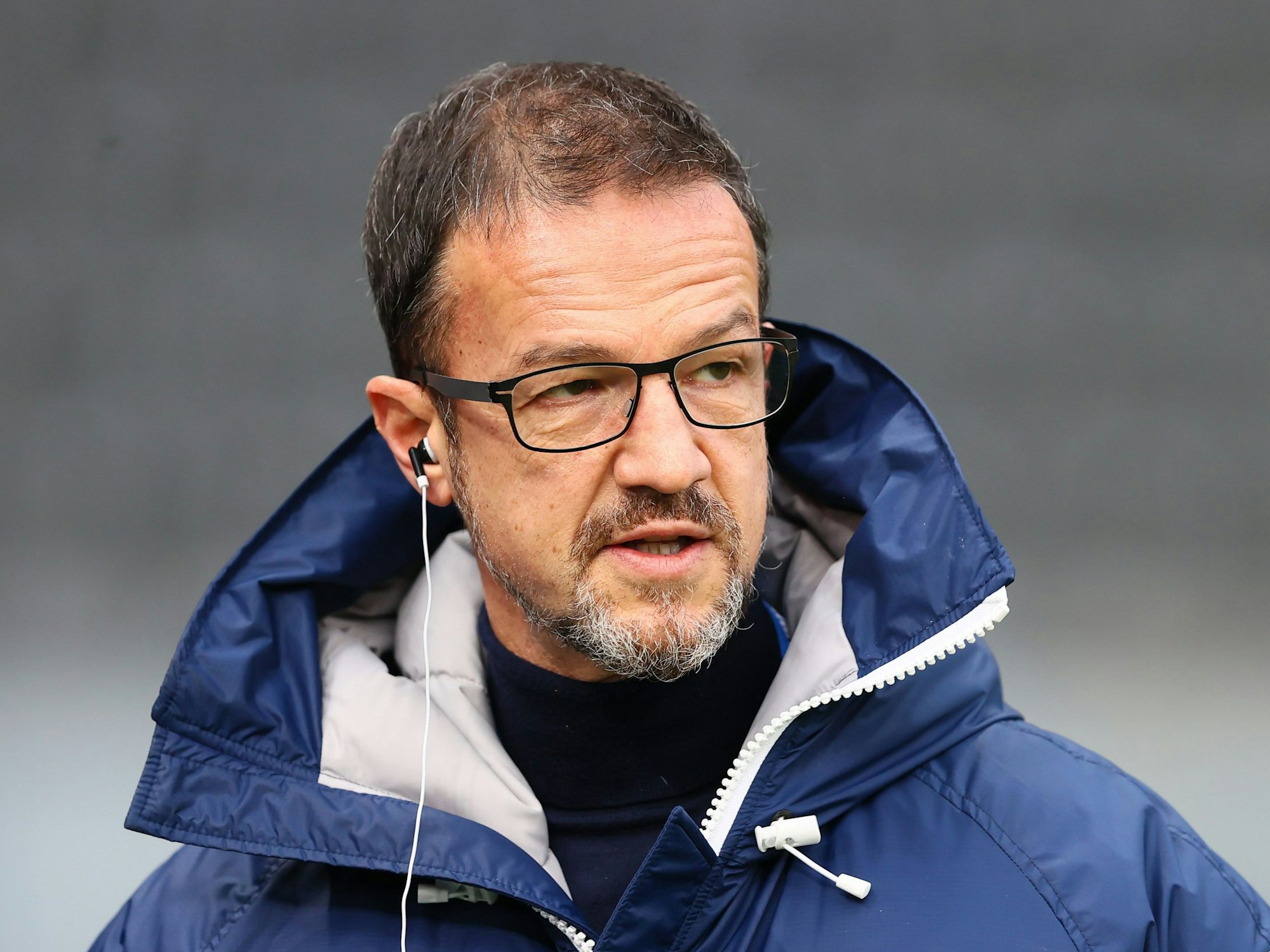 Fredi Bobic mit Kopfhörer im Ohr beim Spiel zwischen Hertha BSC und dem 1. FC Köln.