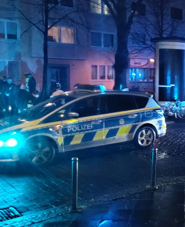 Zwei Polizeifahrzeuge und ein RTW stehen nachts auf einer Straße.