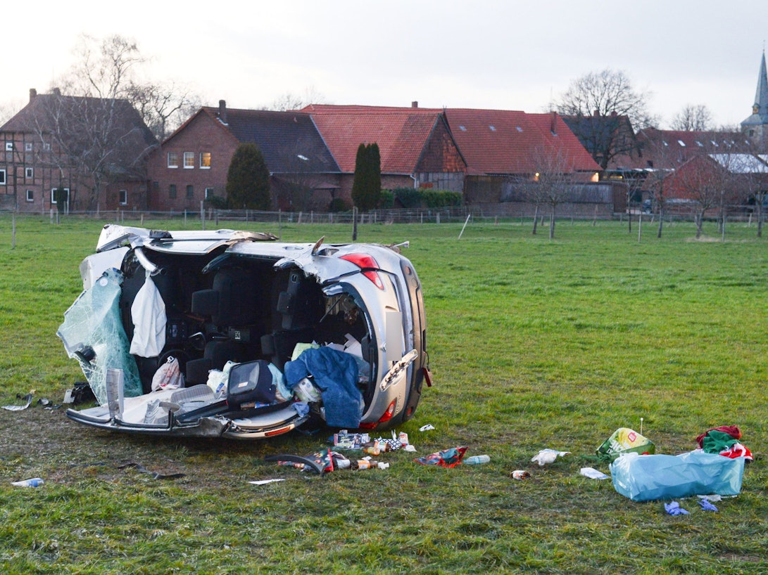 Ein zerstörtes Auto liegt auf einer Wiese. Bei einem Frontalzusammenstoß zweier Autos bei Barsinghausen in der Region Hannover sind zwei Kinder gestorben. Die Polizei ermittelt wegen eines illegalen Autorennens.