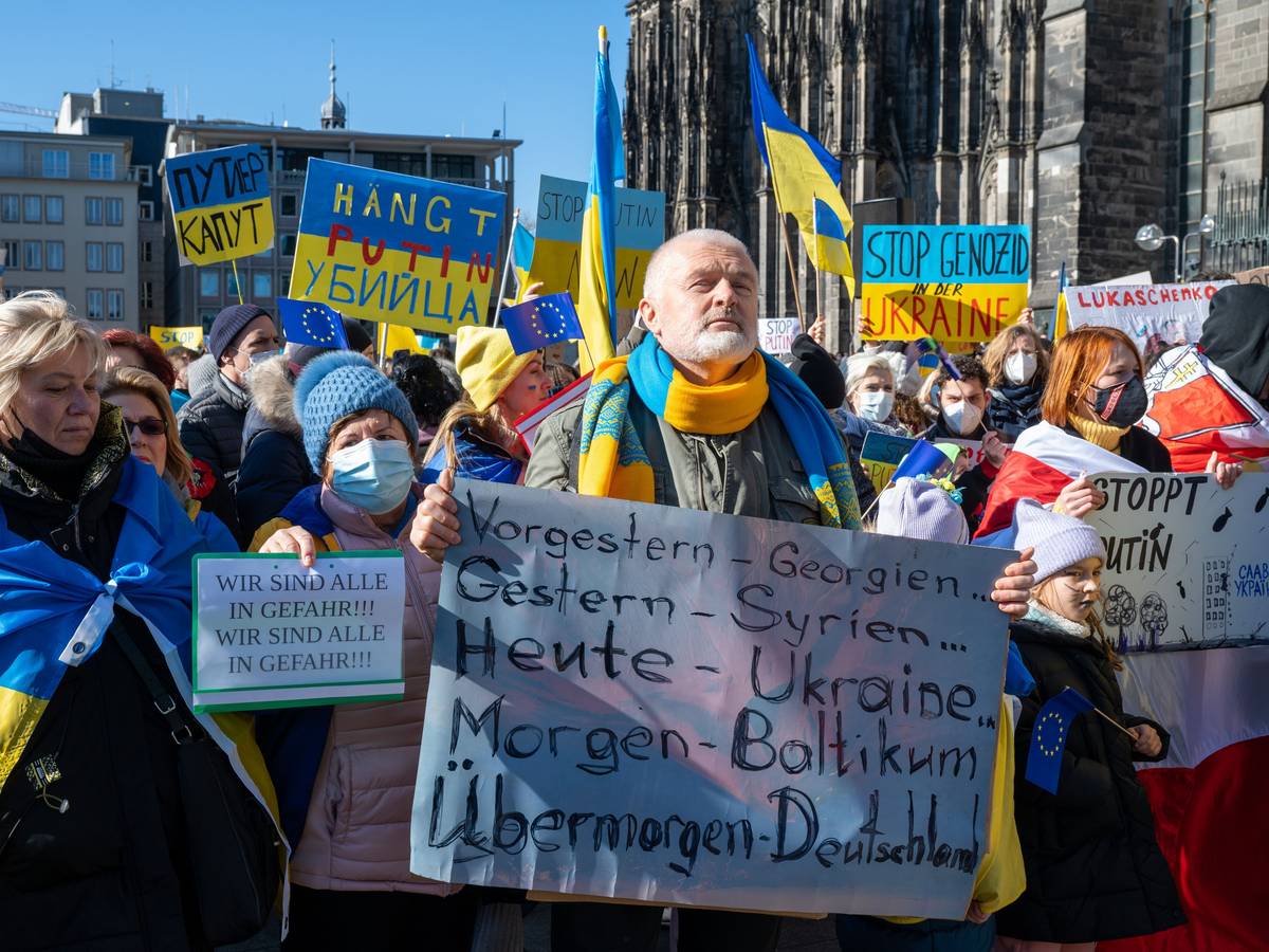 Menschen demonstrieren mit Ukraine-Flaggen gegen den Krieg.