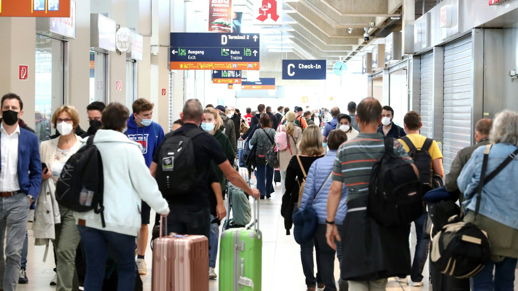 Reisende gehen durch den Flughafen Köl/Bonn.
