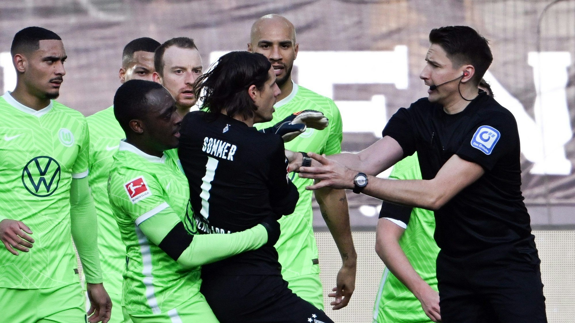 Mönchengladbachs Torwart Yann Sommer (M) diskutiert mit Schiedsrichter Tobias Reichel (r).