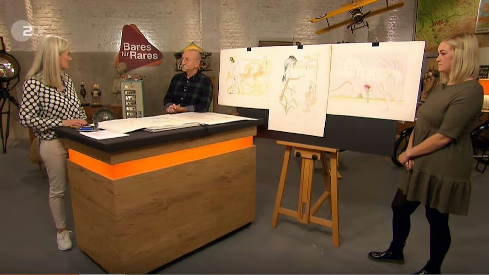 Bares für Rares (ZDF, Ausstrahlung: 28.02.2022)
Horst Lichter mit Expertin Dr. Friederike Werner (l.) und Verkäuferin Rebecca Hansen
Foto: ZDF/Screenshot