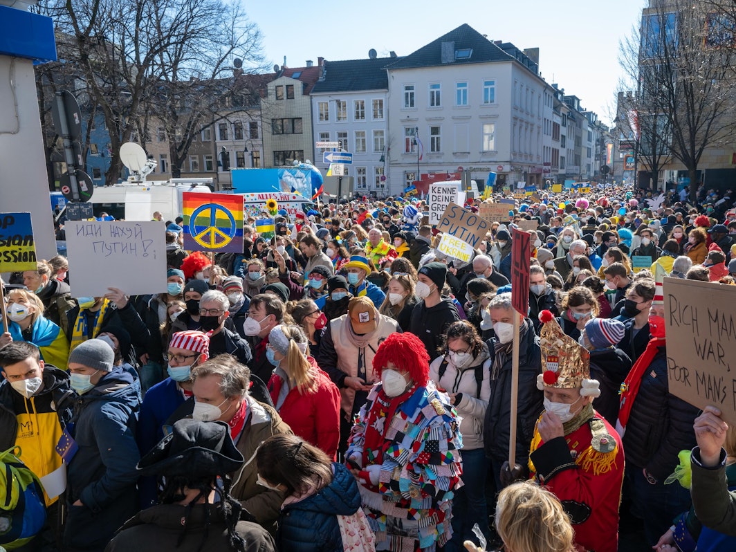 Menschen gehen mit der Friedensdemo durch Köln.