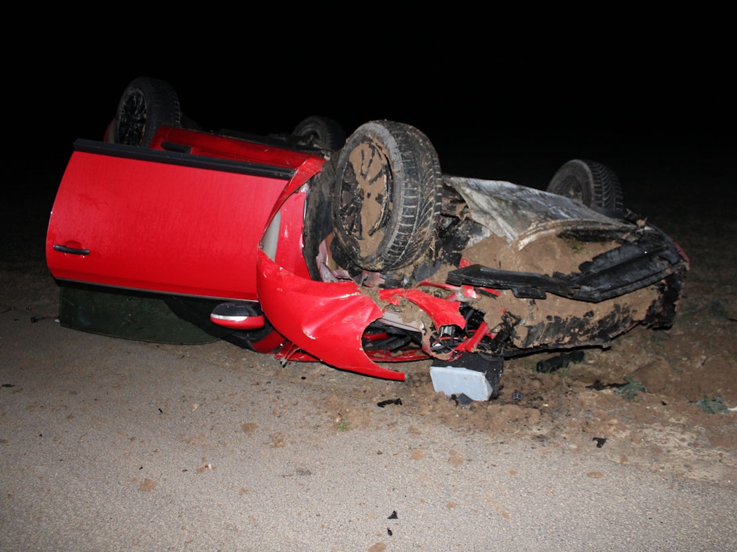 Ein rotes Auto überschlug sich und liegt auf einem Feld in Vettweiß.