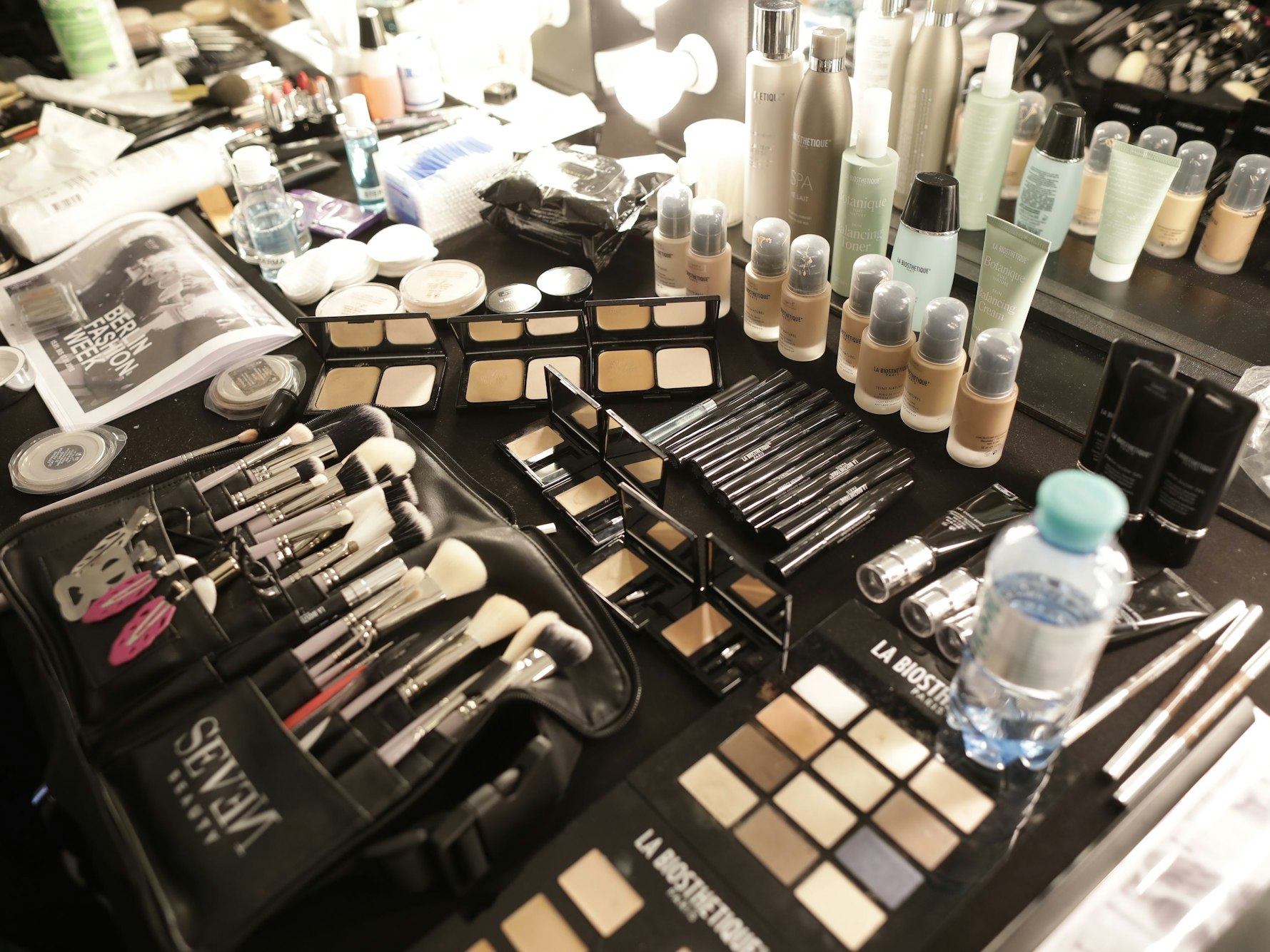 Etliche Schmink-Utensilien liegen auf einem Tisch.