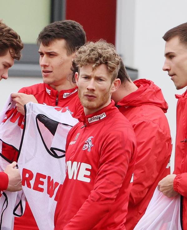Luca Kilian, Dejan Ljubicic, Florian Kainz und Tim Lemperle ziehen sich beim Training es 1. FC Köln (22. Februar 2022) Leibchen an.