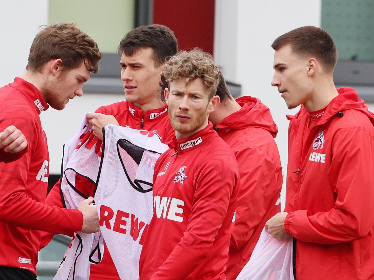 Luca Kilian, Dejan Ljubicic, Florian Kainz und Tim Lemperle ziehen sich beim Training es 1. FC Köln (22. Februar 2022) Leibchen an.