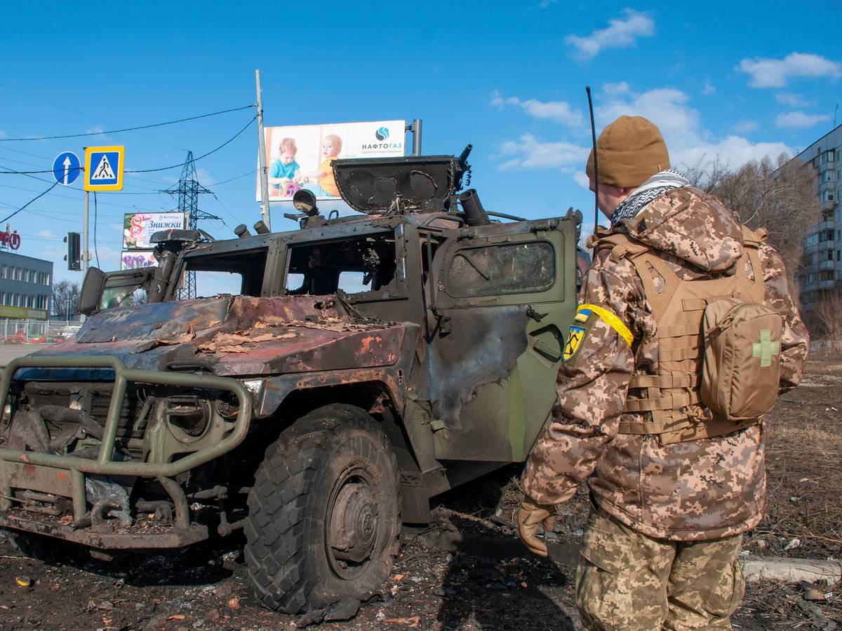 Ein ukrainischer Soldat inspiziert ein beschädigtes Militärfahrzeug.