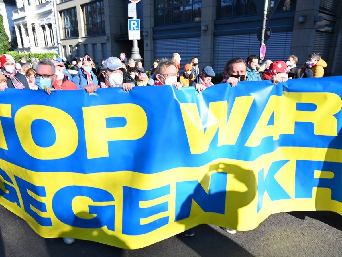 Die Führungsetage des 1. FC Köln hinter dem Banner „Stop War – Wir gegen Krieg“ am Rosenmontag, 20. Februar 2022 in Köln