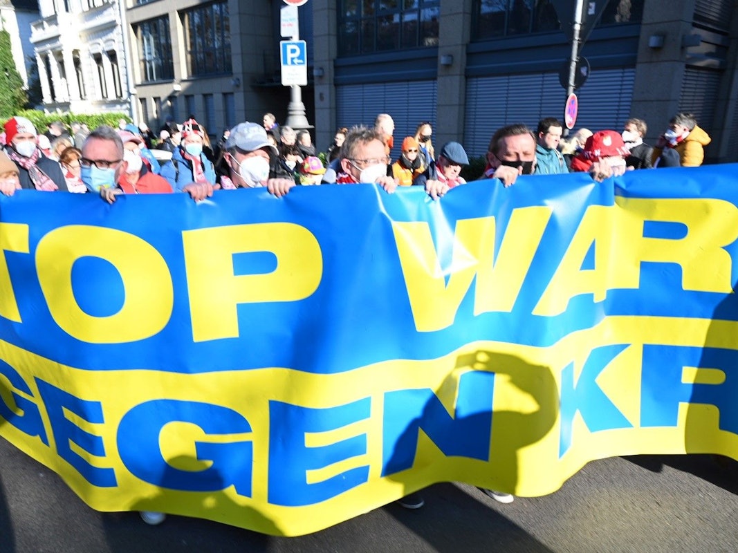 Die Führungsetage des 1. FC Köln hinter dem Banner „Stop War – Wir gegen Krieg“ am Rosenmontag, 20. Februar 2022 in Köln