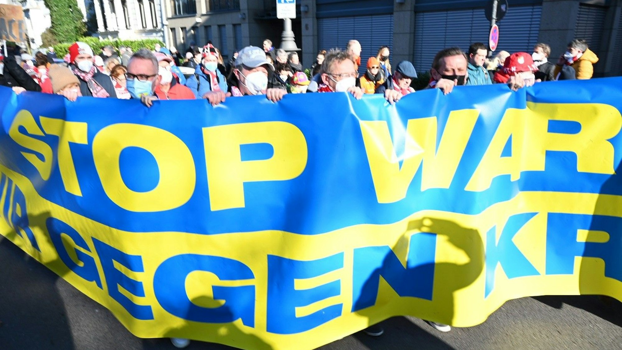 Die Führungsetage des 1. FC Köln hinter dem Banner „Stop War – Wir gegen Krieg“ am Rosenmontag, 20. Februar 2022 in Köln