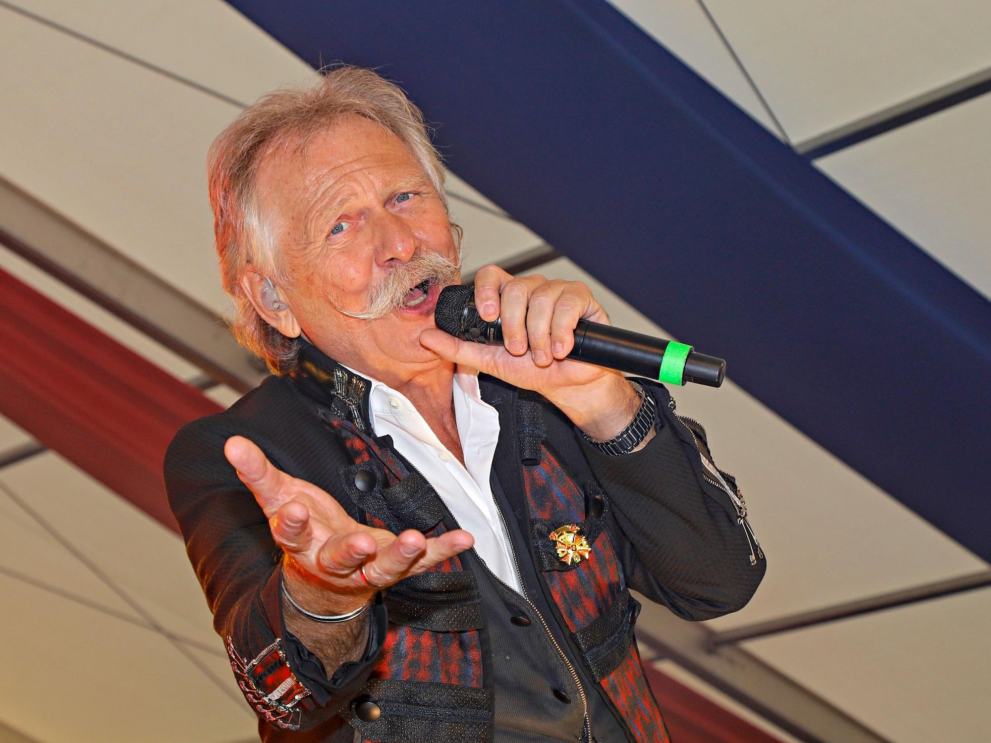 Henning Krautmacher singt und lacht in die Kamera.