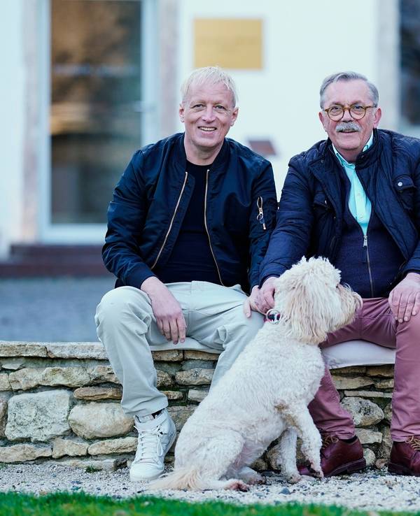 Robert Boudier (rechts) und Elmar Koeller, Inhaber des Weinguts Boudier und Koeller, sitzen im Innenhof ihres Weinguts in Stetten, Rheinland-Pfalz.