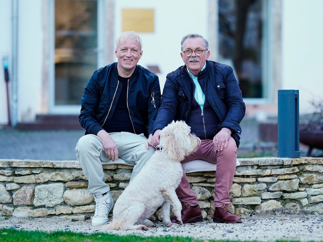 Robert Boudier (rechts) und Elmar Koeller, Inhaber des Weinguts Boudier und Koeller, sitzen im Innenhof ihres Weinguts in Stetten, Rheinland-Pfalz.