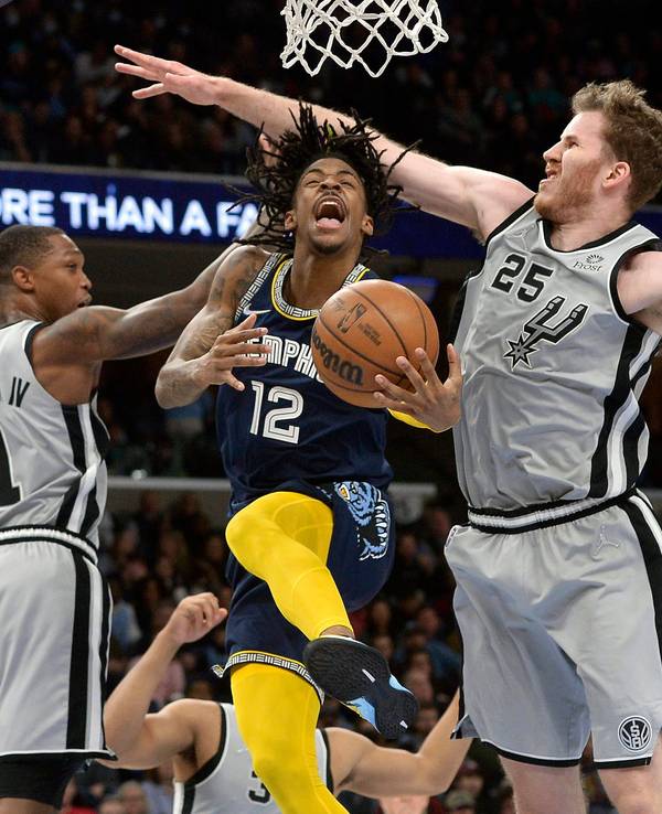 Ja Morant springt zwischen Lonnie Walker IV und Center Jakob Pöltl in der zweiten Halbzeit gegen die San Antonio Spurs durch.