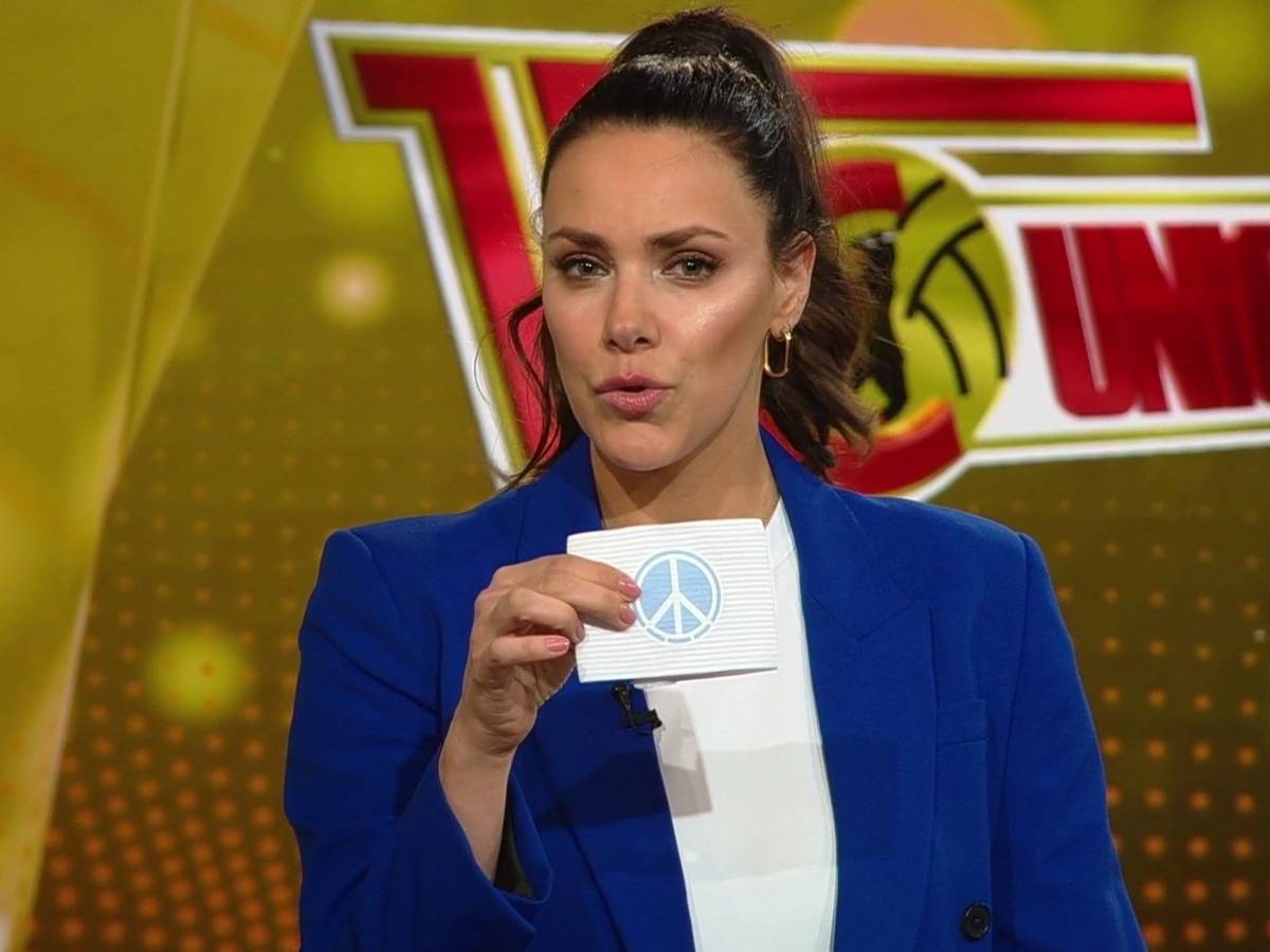 Esther Sedlaczek hält bei ihrem TV-Comeback in der ARD die Armbinde mit dem Peace-Symbol in die Kamera, mit der Union Berlin und der FC St. Pauli im Pokal-Duell aufliefen.