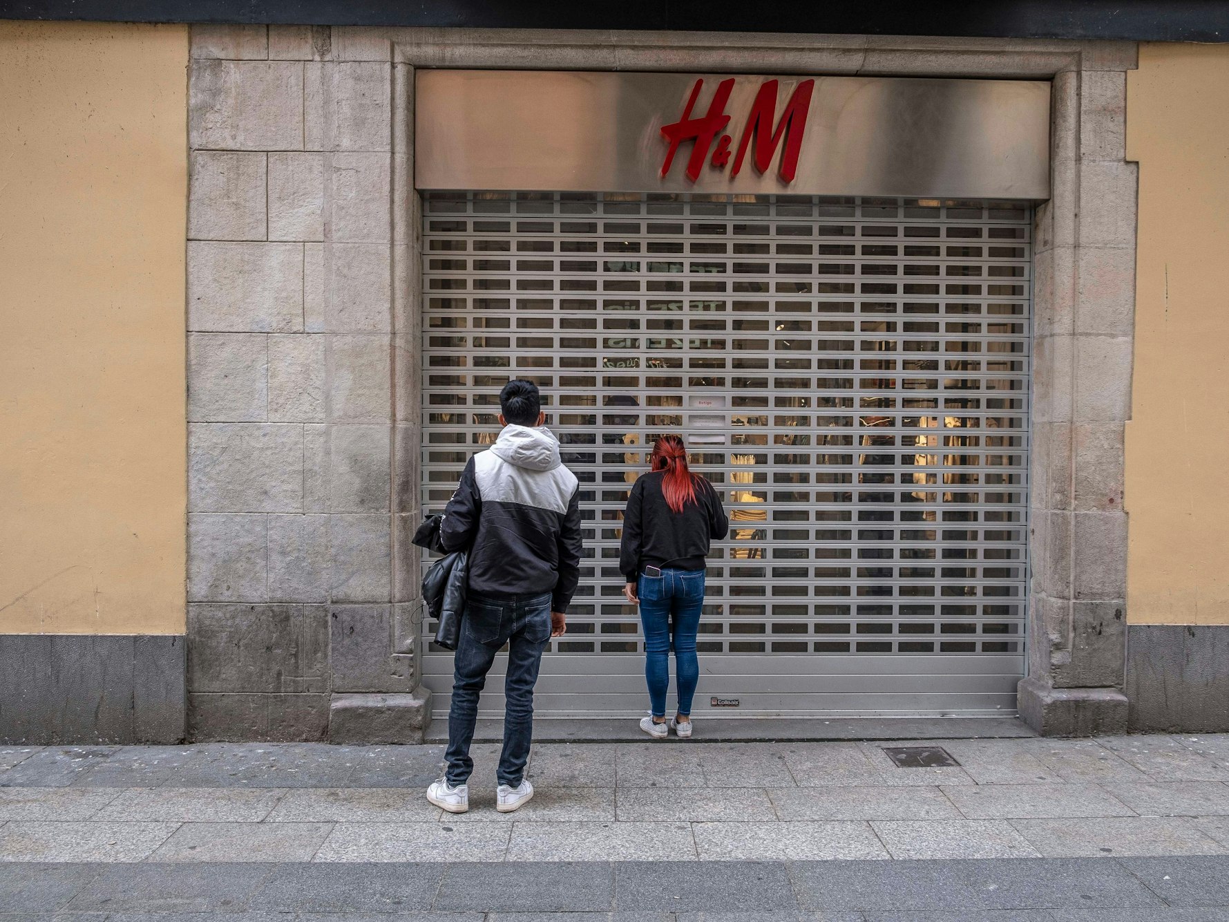 Passanten stehen vor einer geschlossenen H&M-Filiale (Archivfoto).
